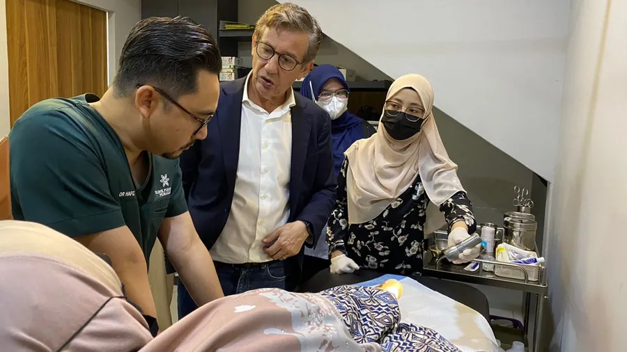 Doktor dan jururawat Primakasih bersama seorang pesakit warga emas di bilik rawatan.